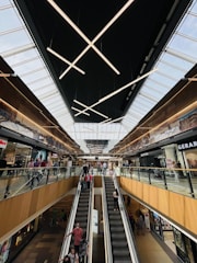 A modern escalator bustling with people in a shopping mall.