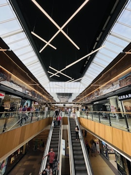 A modern escalator bustling with people in a shopping mall.
