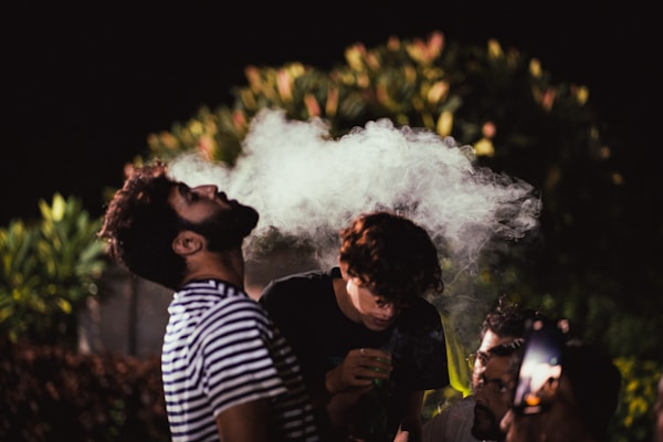 man in black and white striped shirt smoking