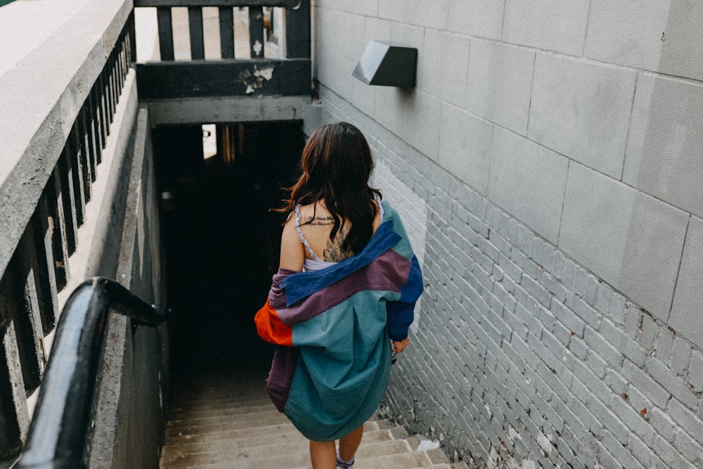 woman in blue and red dress standing on gray concrete floor