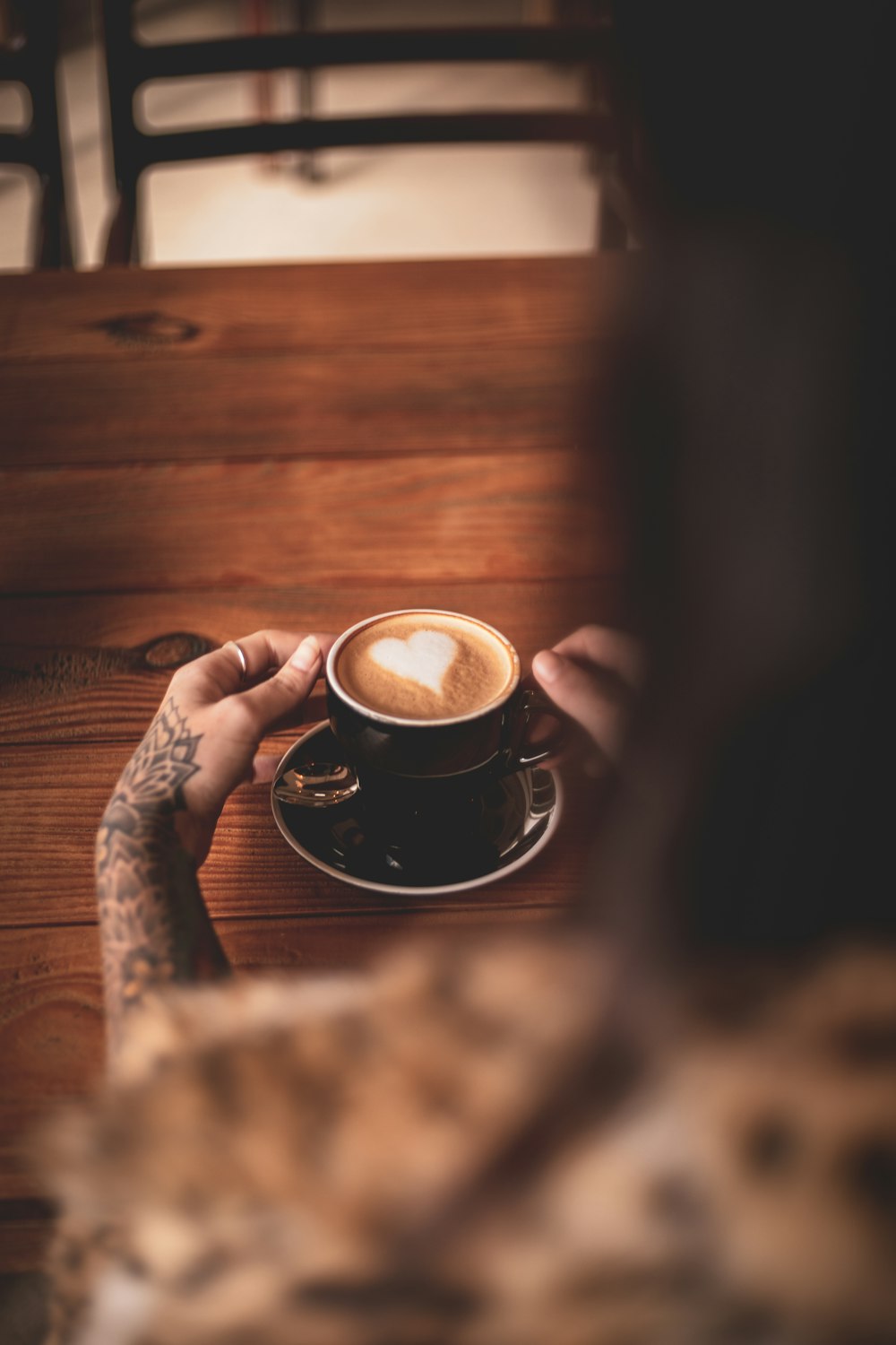 Persona che tiene la tazza di ceramica nera con il caffè