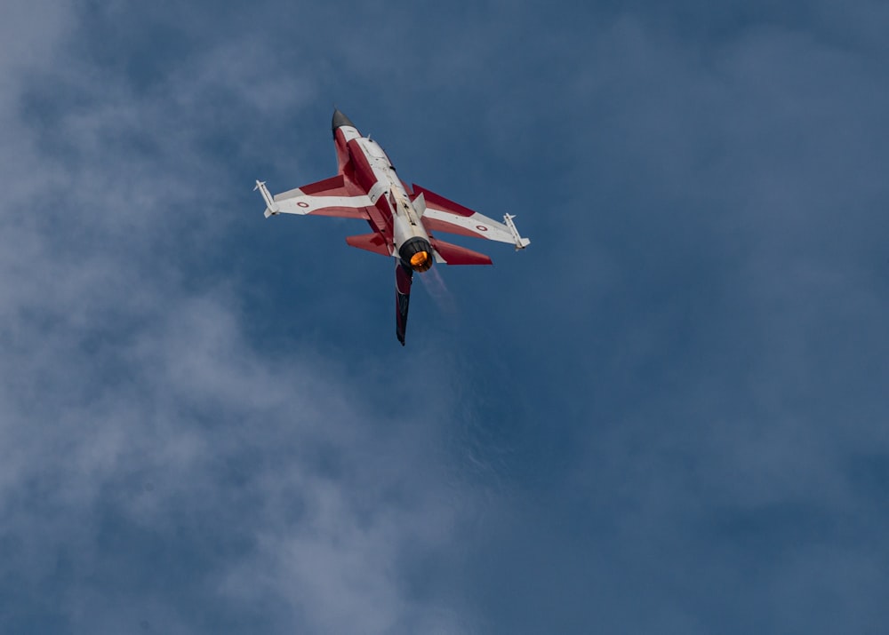 red and white airplane flying in the sky