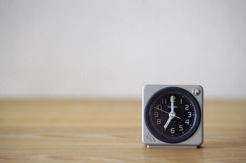 white and black analog desk clock