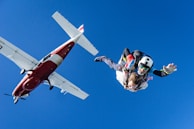 white and red airplane in mid air during daytime