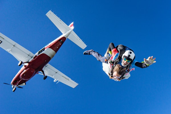 Skydivers jumping from a small aircraft in a deep blue sky