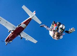 white and red airplane in mid air during daytime