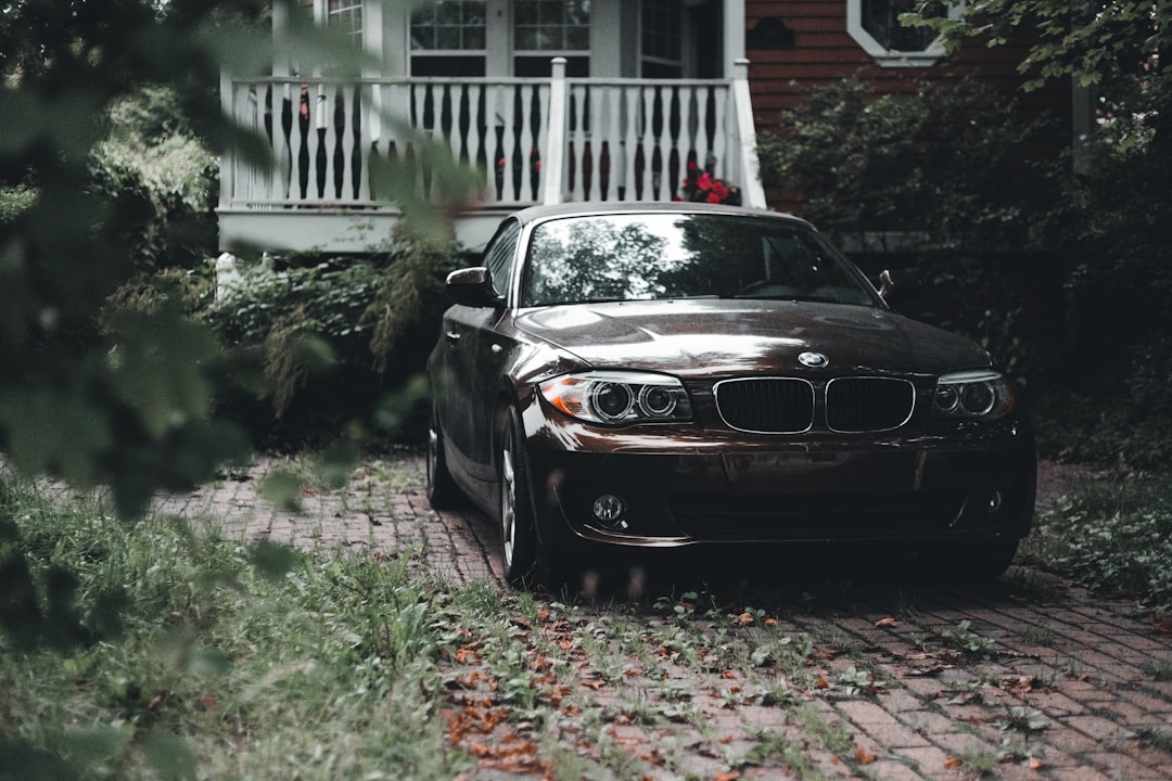 black bmw m 3 parked near white house during daytime,