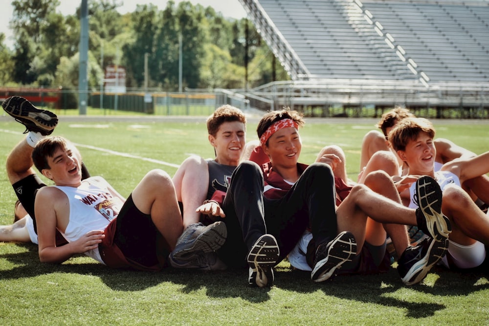 group of people sitting on green grass field during daytime