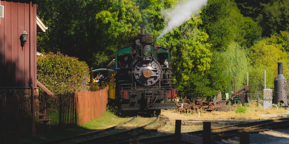 green and black train on rail tracks during daytime