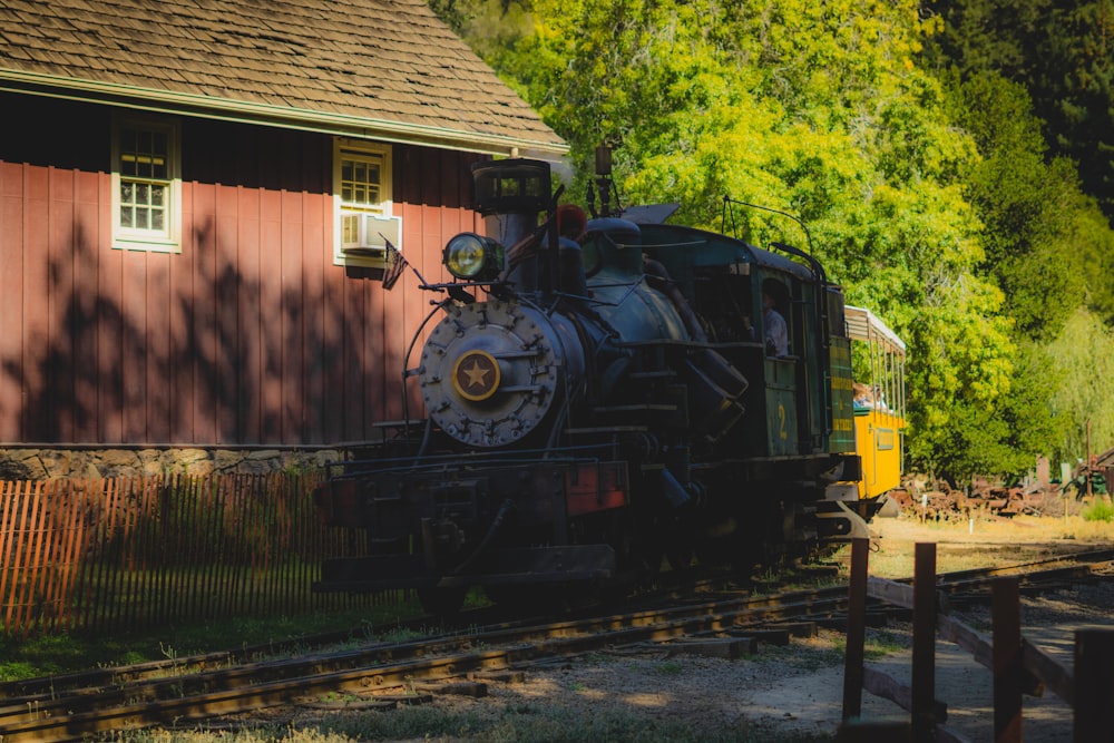 black train near brown wooden house during daytime