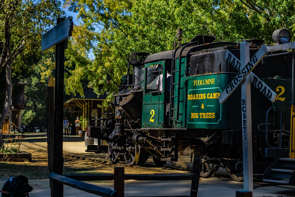 green train on rail road during daytime