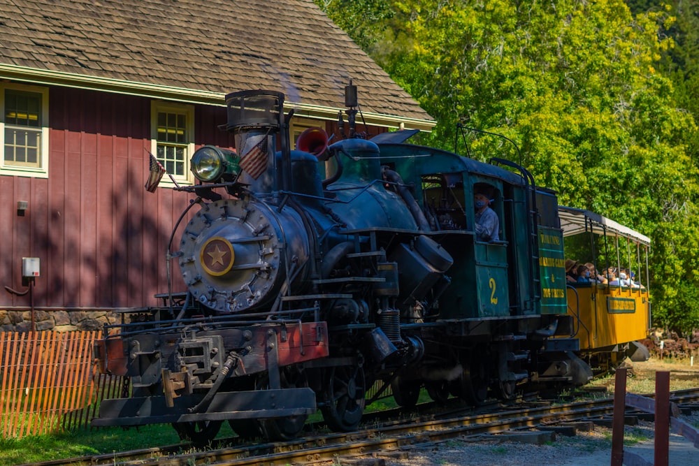 green and brown train near brown concrete building during daytime