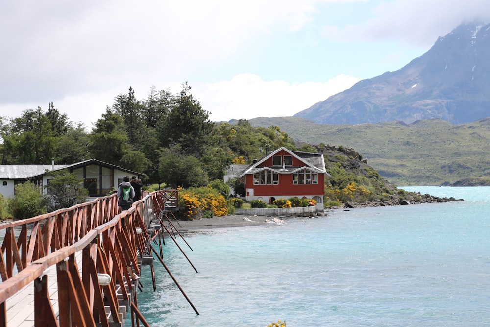 red and white wooden house near body of water during daytime