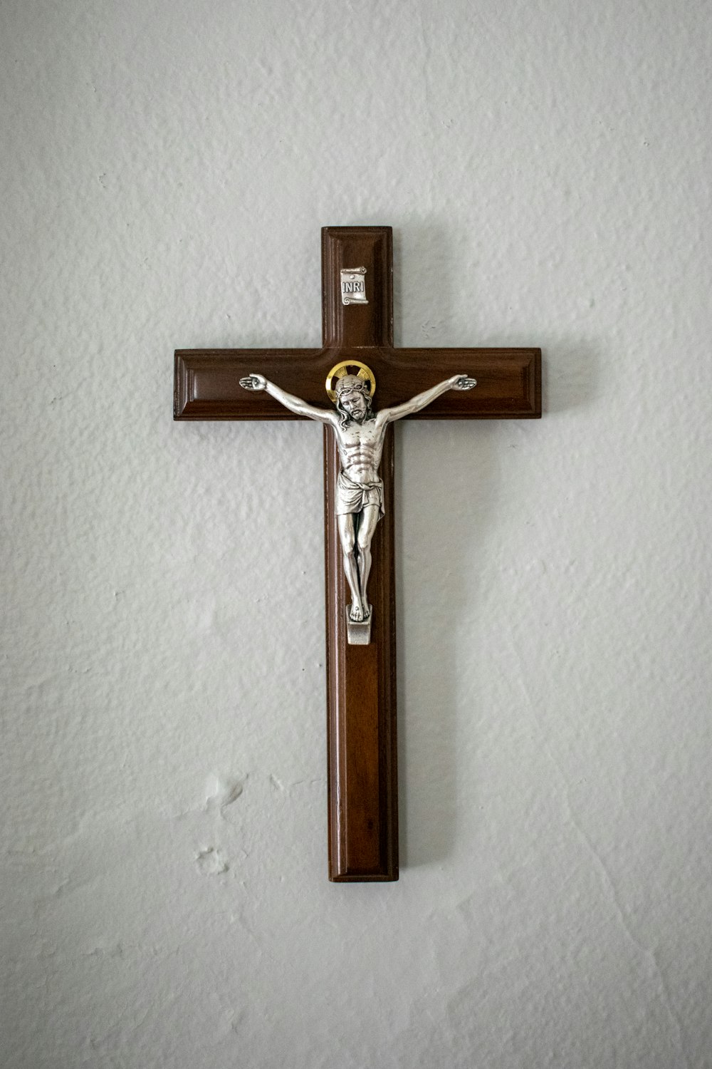白い壁に取り付けられた茶色の十字架