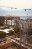 yellow tower crane near building during daytime