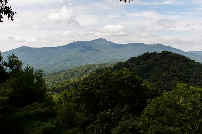 Green trees on a mountain ridge under clouds, similar to the view from Chimney Rocks overlook in Blair Township, PA
