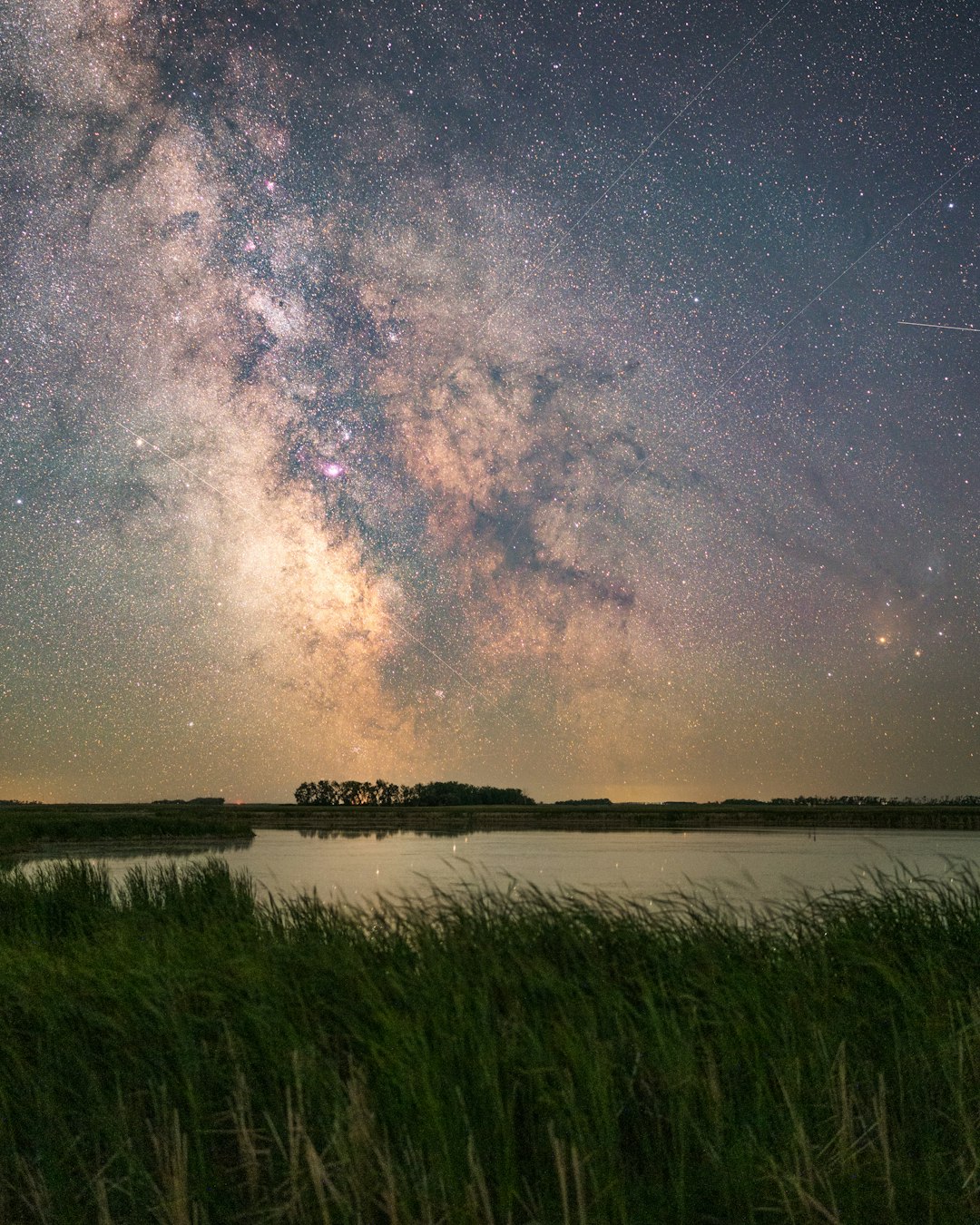 green grass field near lake under starry night