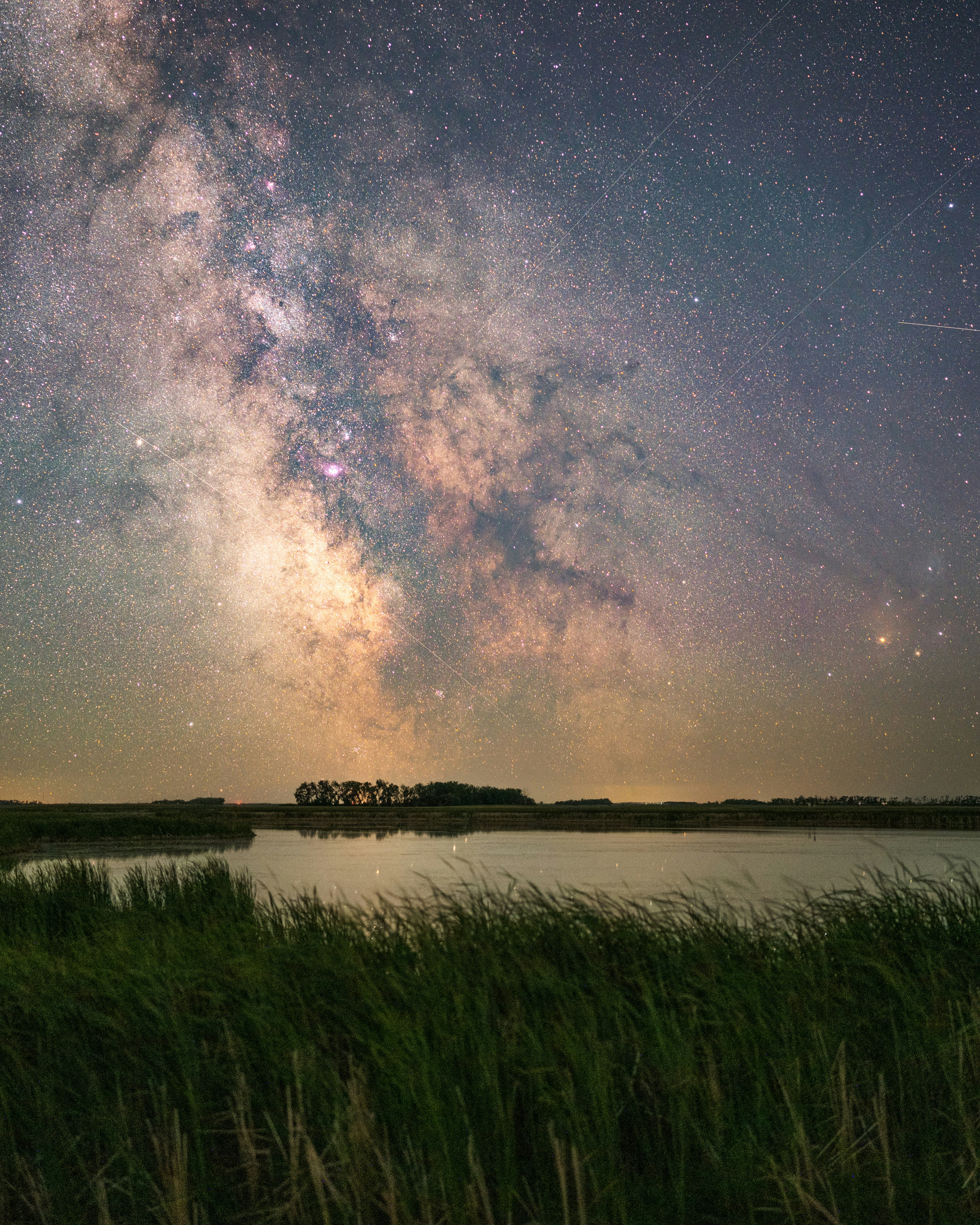 green grass field near lake under starry night