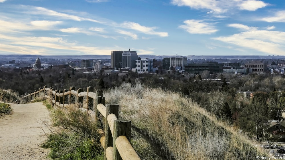 Campo de hierba verde cerca de los edificios de la ciudad bajo el cielo azul durante el día