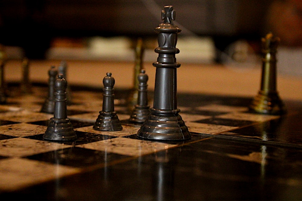 schwarze Schachfigur auf braunem Holztisch