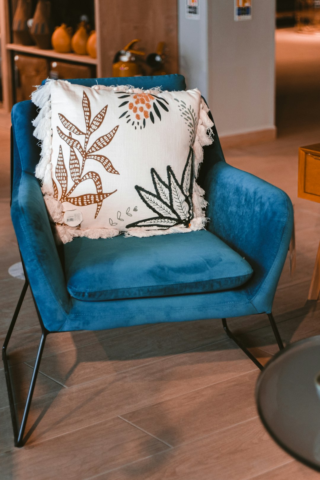 white and black floral throw pillow on blue sofa chair