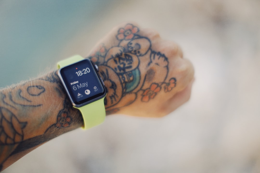 person wearing silver apple watch with green sport band