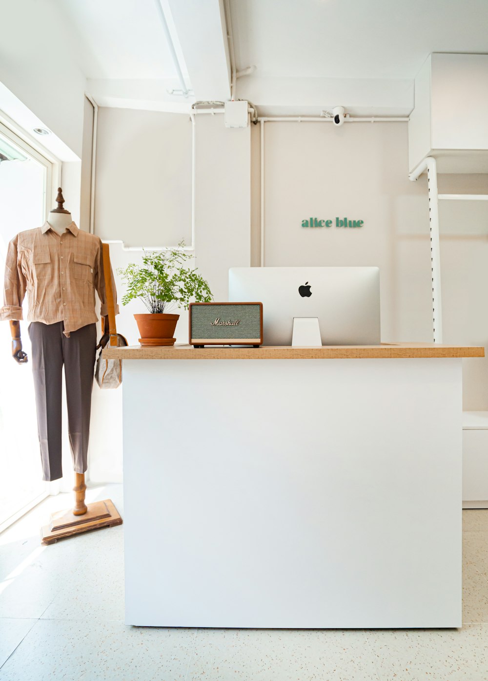 man in brown dress shirt standing in front of white wooden desk