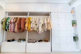 orange and yellow clothes hanged on white wooden cabinet