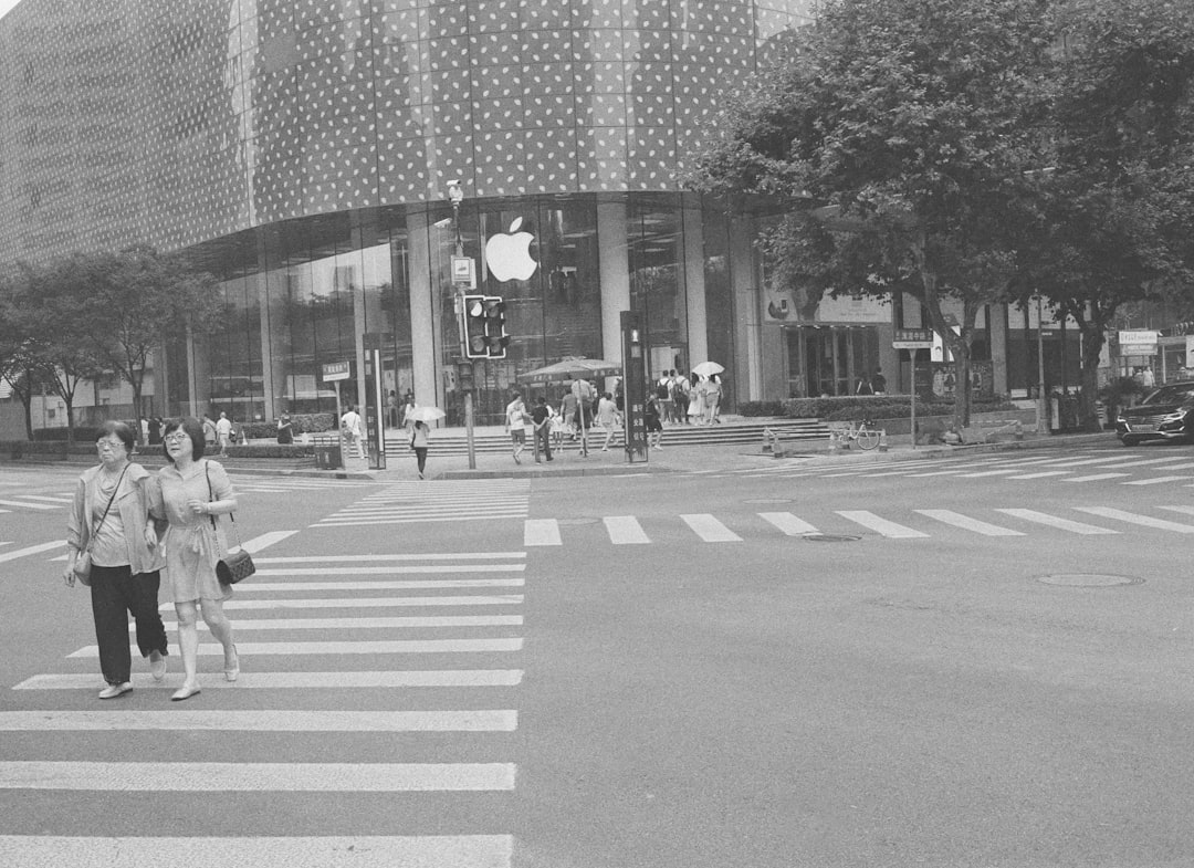 grayscale photo of people walking on pedestrian lane