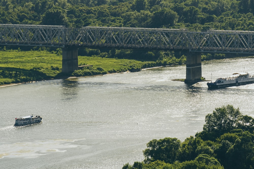 a boat traveling down a river under a bridge