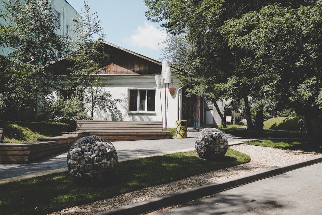 white and brown house near green trees during daytime