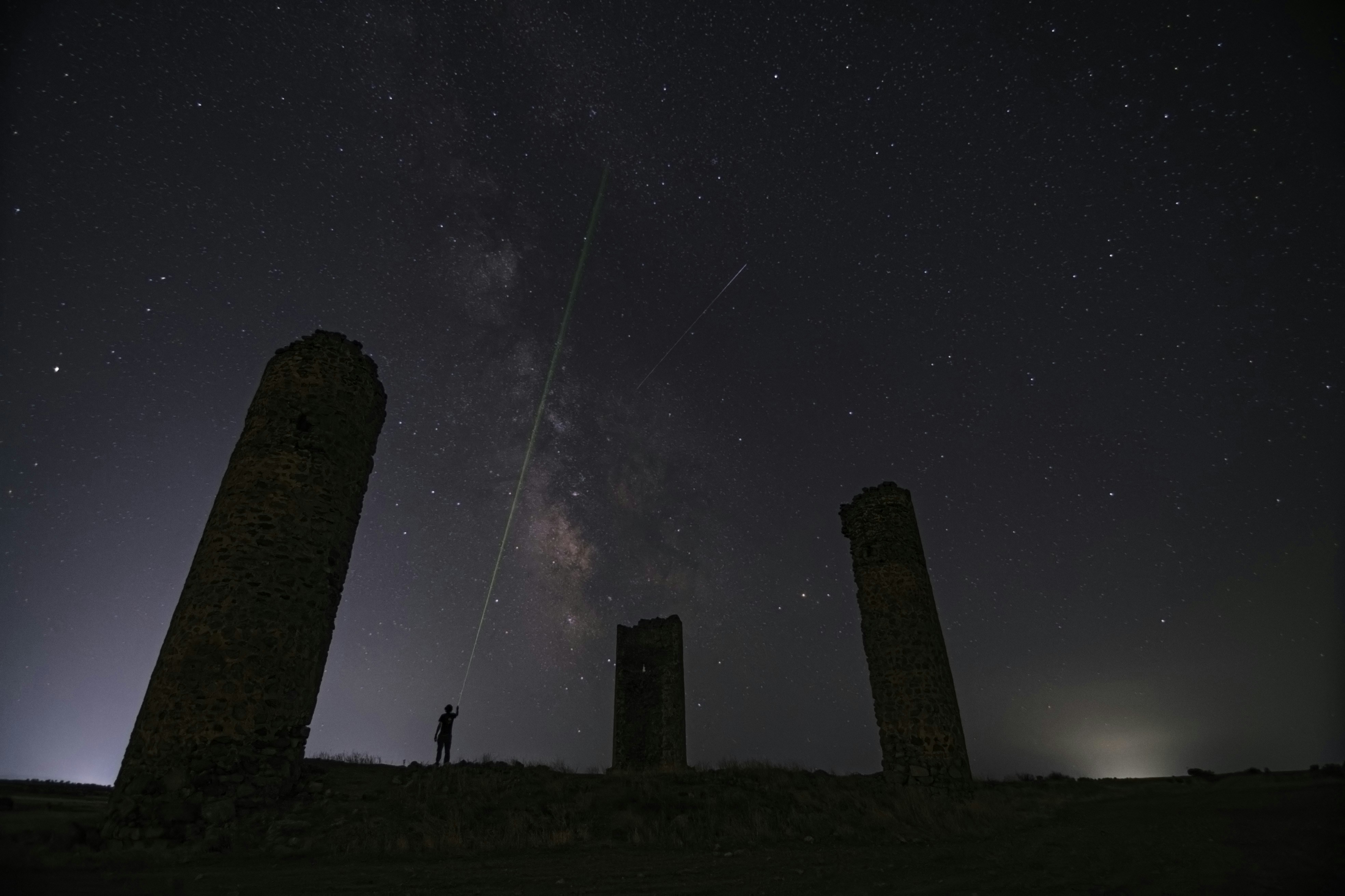 person standing on green grass field under starry night