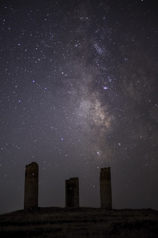 Galen and his companions gathered around an ancient tower under a starry sky.