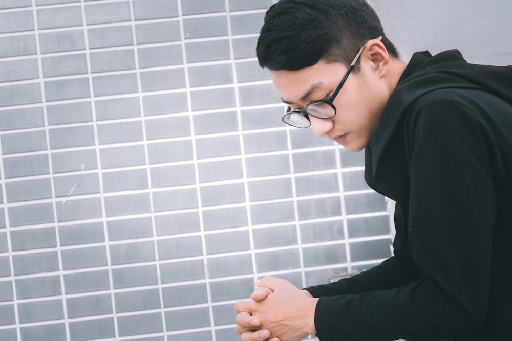 man in black long sleeve shirt wearing black framed eyeglasses