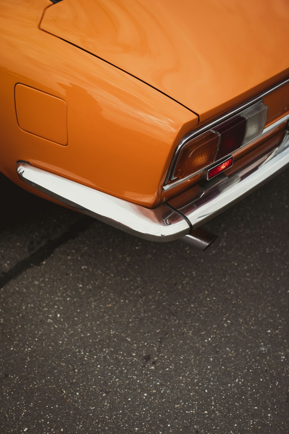 灰色のアスファルト道路のオレンジ色の車