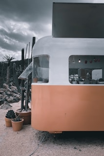 Close-up of a cozy trailer home with flower pots and a small porch at Palmetto Trailer Estates.