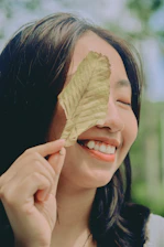 A happy patient receiving herbal treatment with a warm smile from the practitioner.