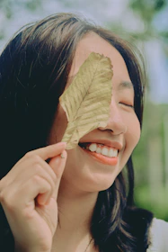 A happy patient receiving herbal treatment with a warm smile from the practitioner.