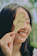 Close-up photo of a person smiling gently while holding a fresh neem dattoon.