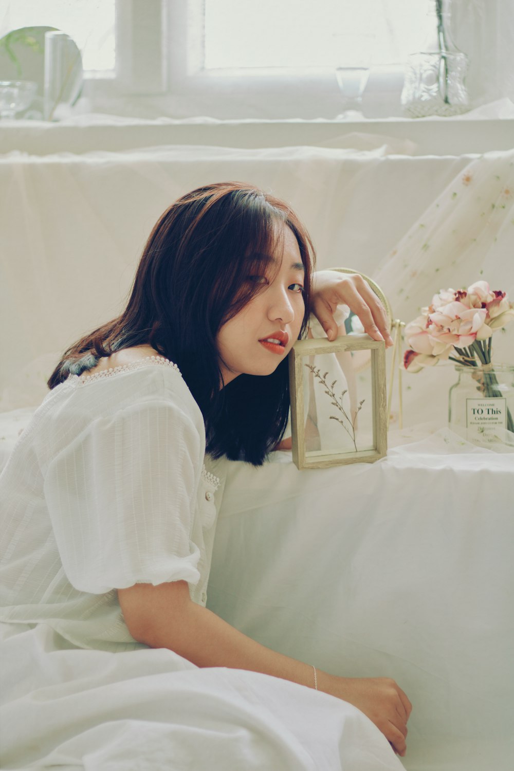 woman in white shirt holding gold box