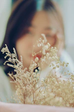 A soft, dreamy illustration of a woman surrounded by gentle light and delicate flowers.