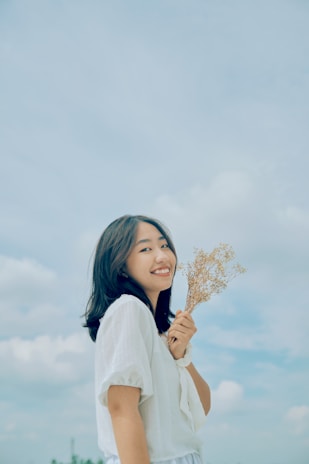 A serene photo of a young Kenyan woman smiling gently, holding a par-care sanitary pad package.