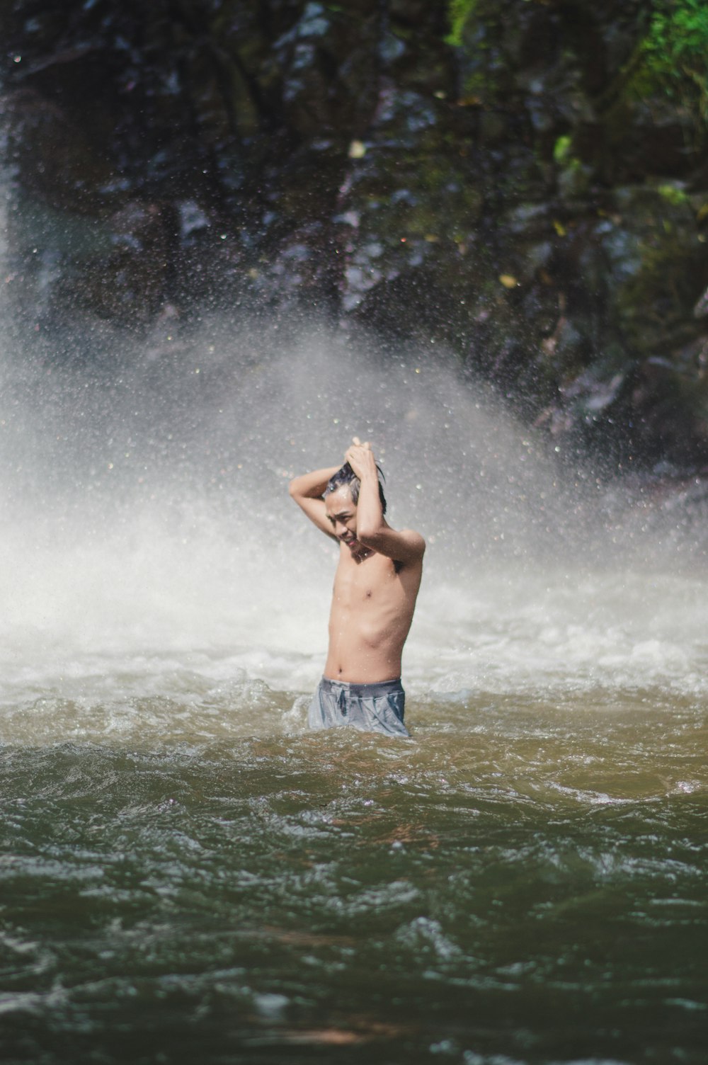 man in blue shorts standing on water