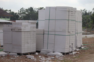 Close-up of sturdy cement bags stacked neatly on a wooden pallet in a warehouse.