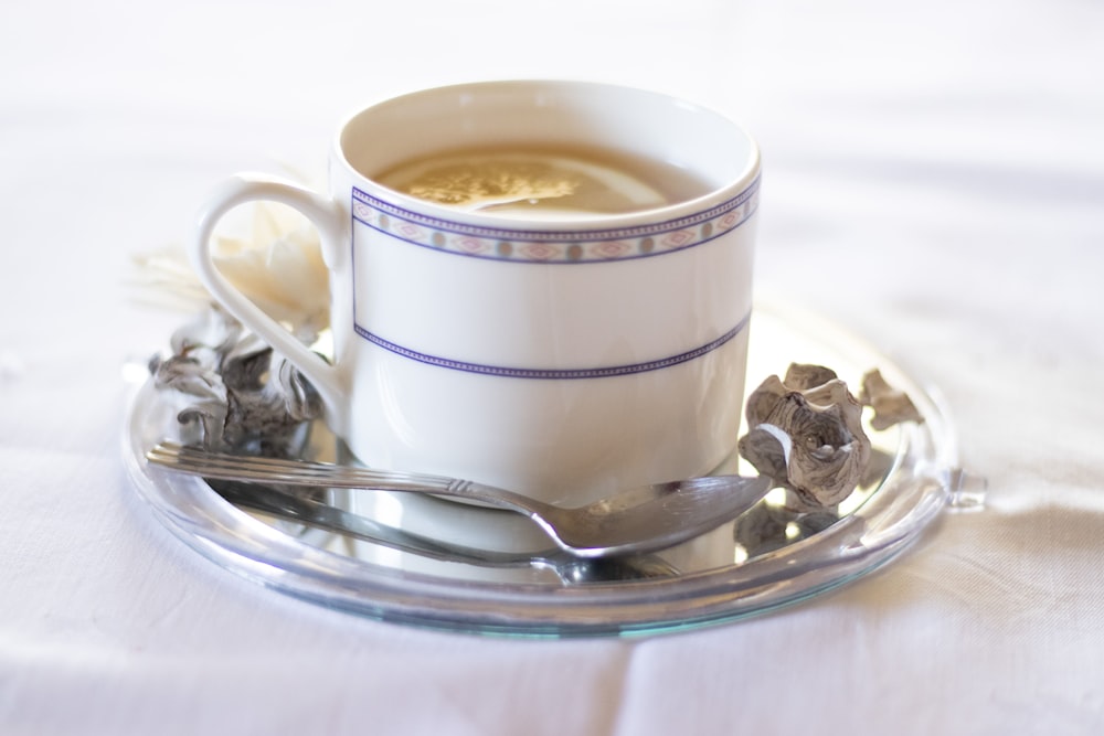 white ceramic cup on silver saucer