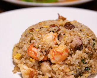 cooked rice with green peas and sliced carrots on white ceramic plate