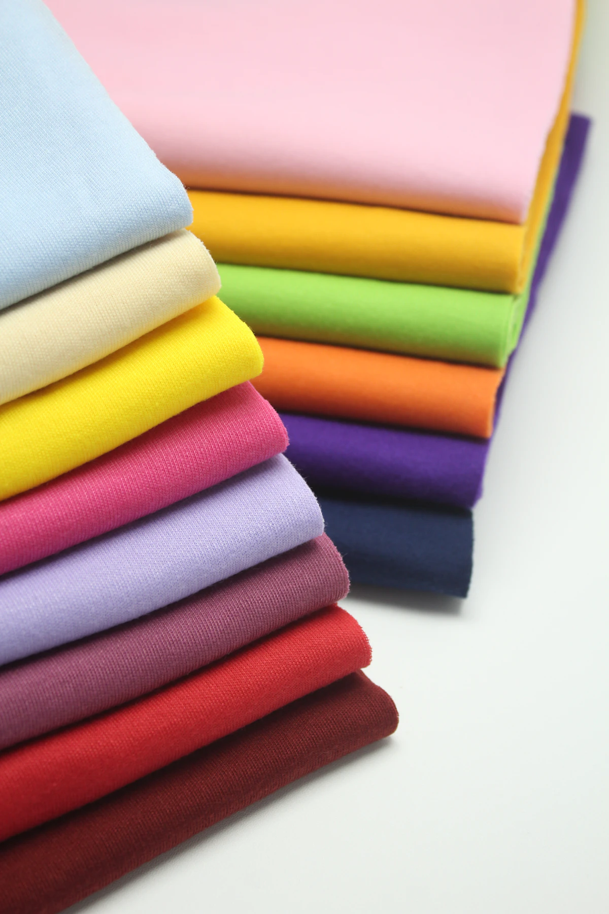 Stack of rich, colourful folded textiles