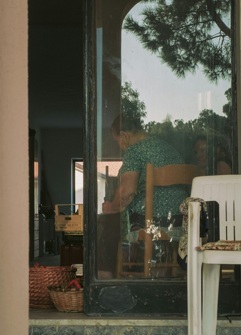 woman in blue and white floral dress standing near glass door