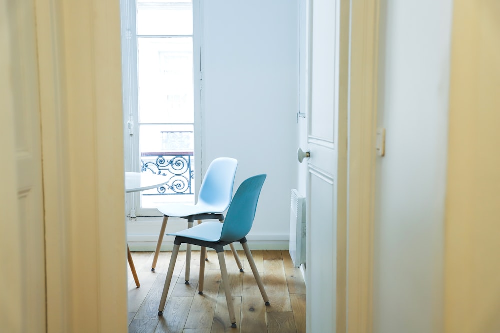 blue and black chair beside white wooden door