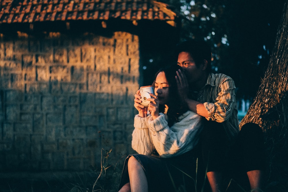 woman in white and black stripe shirt sitting on mans lap